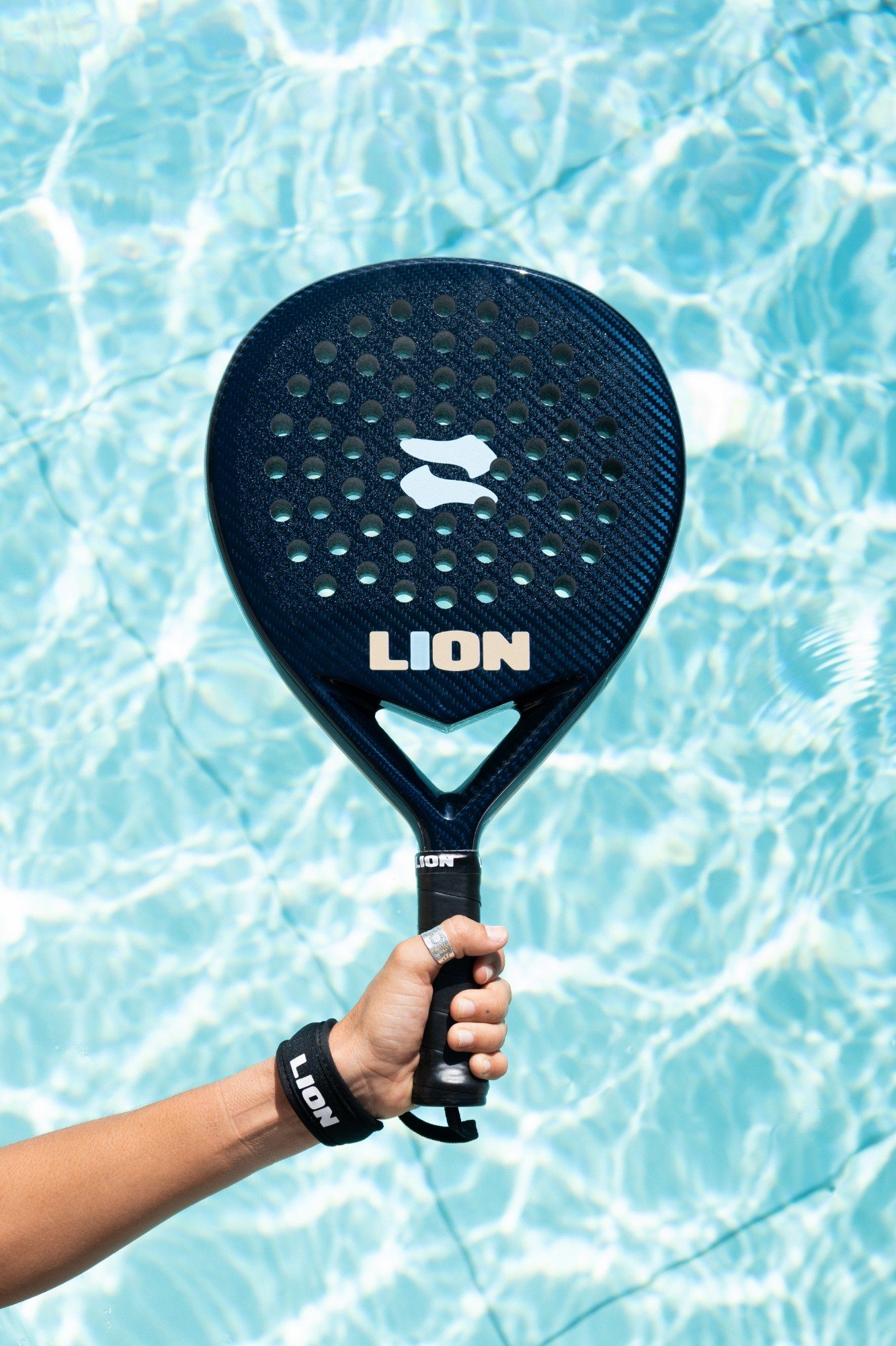 Pala LION azul sostenida sobre el agua de una piscina